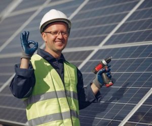 Technician installing rooftop solar panels on a residential house for clean energy generation
