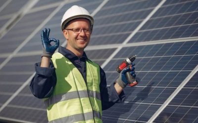 Technician installing rooftop solar panels on a residential house for clean energy generation