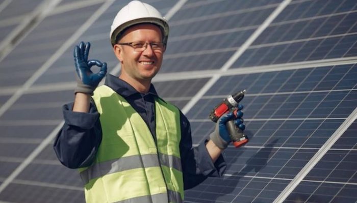 Technician installing rooftop solar panels on a residential house for clean energy generation